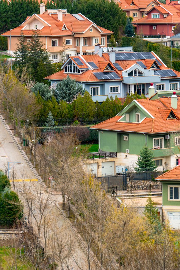 Charming suburban homes with solar panels in Ankara, Turkey, amidst lush greenery.