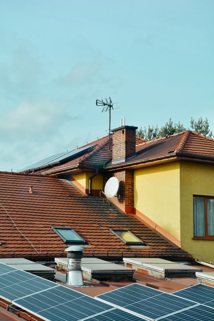 gallery-03 Yellow building with solar panels and antennas on rooftop in Poland. Eco-friendly technology.
